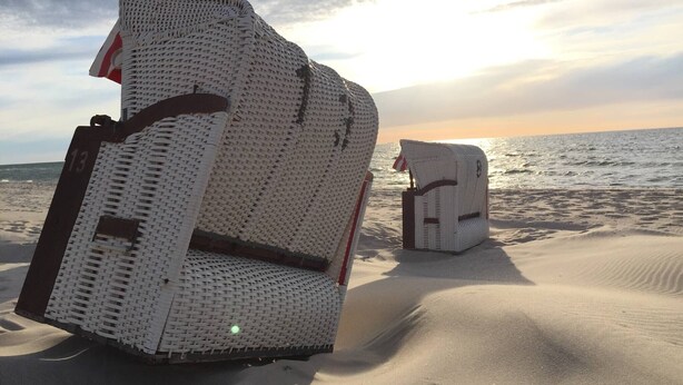 A beach with two white wicker chairs. - Holiday Home 'Charlottes Landlust' with Private Terrace and Garden (Ribnitz-Damgarten)