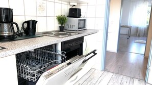 Une cuisine équipée d’un lave-vaisselle, d’une cuisinière, d’un four à micro-ondes et d’une machine à café.