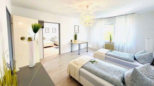 Une chambre d’hôtel moderne dotée d’un grand lit, d’un canapé, d’une table à manger et offrant une vue sur l’extérieur.