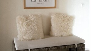 Une estampe botanique encadrée est accrochée au-dessus d’un banc rembourré agrémenté de coussins moelleux.
