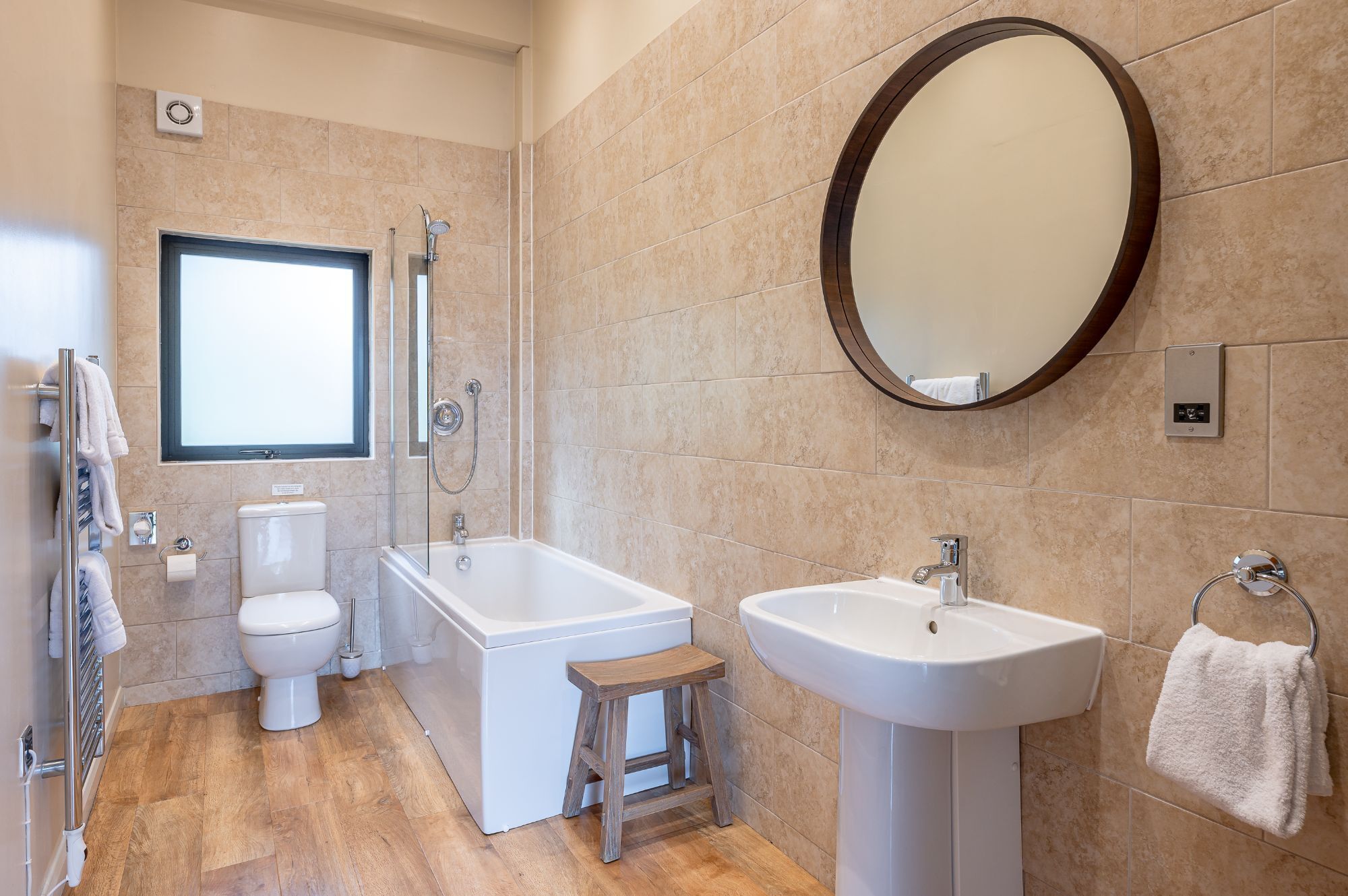 Een moderne badkamer met een bad, toilet en wastafel.
