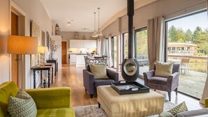 A spacious living room with a fireplace, large windows, and a view of the outdoors. - Abbey -  a lodge that sleeps 6 guests  in 3 bedrooms (Richmond)