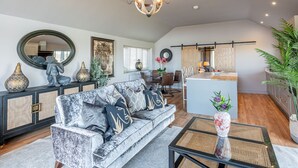 A spacious living room with a sofa, a dining area, and a kitchen. - Bearskin Cottage - Holiday At Home (Leyburn)
