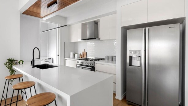 A modern kitchen with a central island, stainless steel appliances, and a wooden ceiling. - Halfway Gem - 3BR Home Between Geelong & The Coast (Mount Duneed)