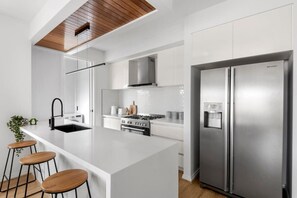A modern kitchen with a central island, stainless steel appliances, and a minimalist design.