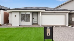 A residential house with a garage, a front door, and a driveway. - Halfway Gem - 3BR Home Between Geelong & The Coast (Mount Duneed)