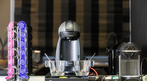 Uma máquina de café, uma cafeteira Krups e um dispensador de cápsulas de café Nespresso Dolce Gusto.