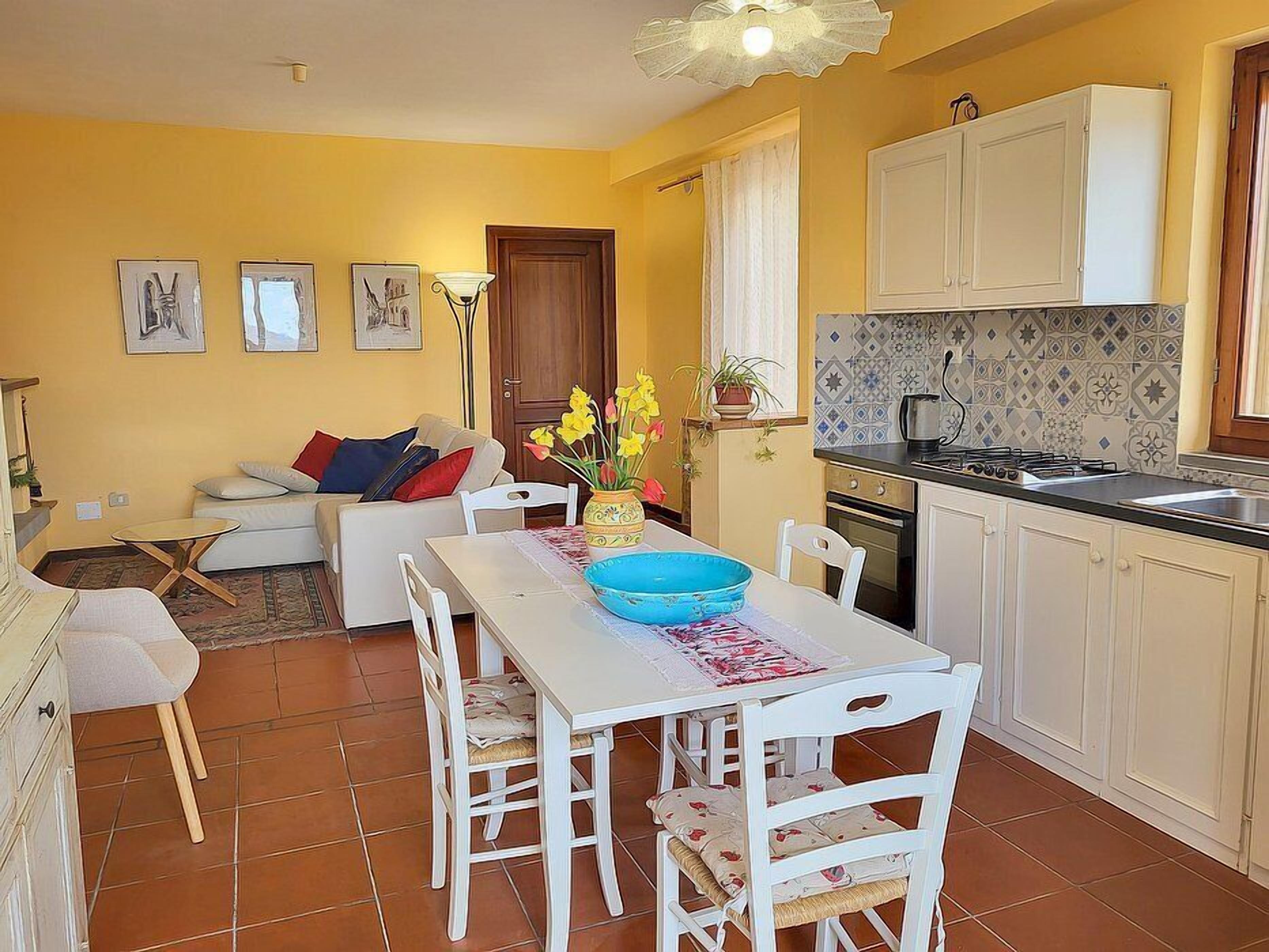 A compact living space with a dining area, kitchenette, and a sofa set.