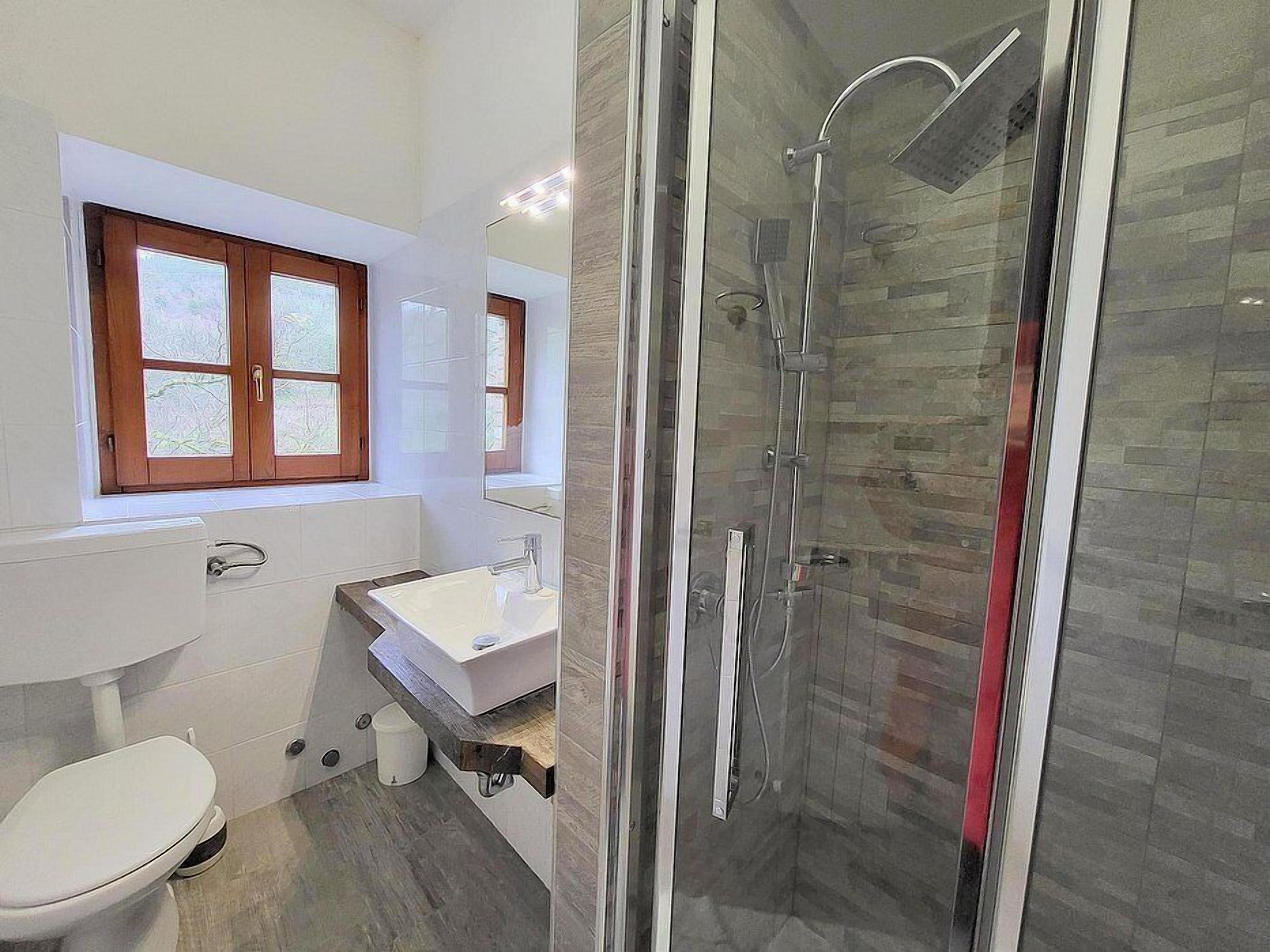 A bathroom with a toilet, sink, and shower.