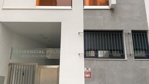 A multi-story residential building with a modern design, featuring a sign indicating it is a residential complex. - Cozy Studio in Distrito Centro Malaga (Málaga)