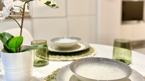 A dining table with plates, a bowl, and a potted plant. - Cozy Studio in Distrito Centro Malaga (Málaga)