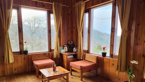A cozy cabin with wooden walls and floors, featuring two wooden benches, a small table, and a potted plant. - Hartola Panorama Cottage (Kosiyakutoli)