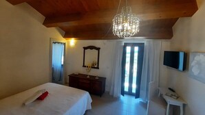 A bedroom with a bed, a dresser, a TV, and a chandelier. - B&B Santo Stefano (Campobasso)