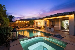 A swimming pool with a stone border, a bar area with stools, and a patio with outdoor furniture. - Private Oasis w/pool & spa. Access to PB, Tennis, & Fitness centre! (Indio)