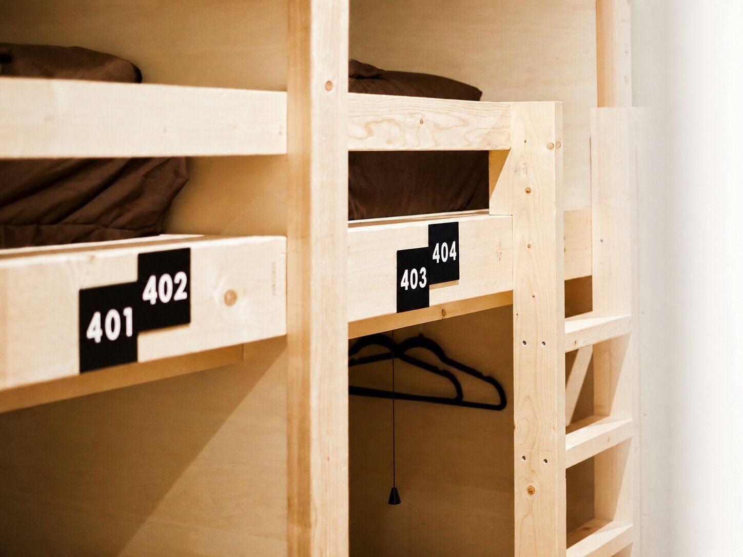 A bunk bed with wooden frames and numbered compartments.