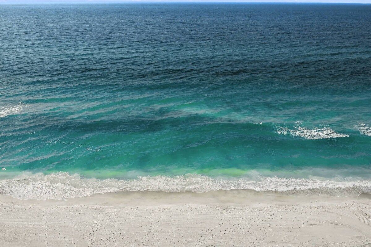 A beach with clear turquoise water and a sandy shore.