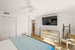 A bedroom with a bed, a dresser, a television, and a ceiling fan. - Walk to Lido Beach & St. Armands! Heated Pool/Spa (Sarasota)