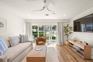 A modern living room with a sofa, armchair, coffee table, and a wooden console.