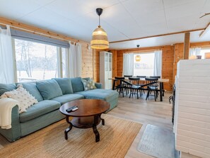 A cozy living room with a sofa, coffee table, and dining area with chairs and a table. - Brofeldt by Interhome (Tohmajärvi)