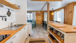 Une cuisine compacte dotée de plans de travail en bois, d’un évier et d’un coin repas avec une table et des chaises.