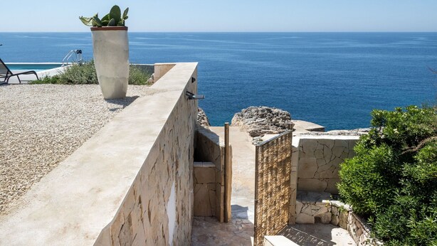 A coastal property with a stone wall, a concrete bench, and a potted plant overlooking the sea. - Stunning private villa with WIFI, private pool, A/C, TV, patio, panoramic view, close to Syracuse (Plemmirio)