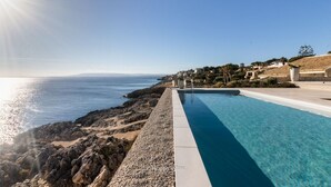 A pool with a clear view of the sea and a rocky shoreline. - Stunning private villa with WIFI, private pool, A/C, TV, patio, panoramic view, close to Syracuse (Plemmirio)