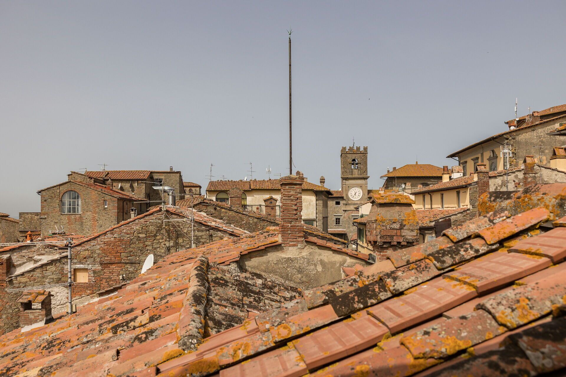 Un poble històric amb arquitectura tradicional, incloent edificis de pedra i una torre del rellotge.