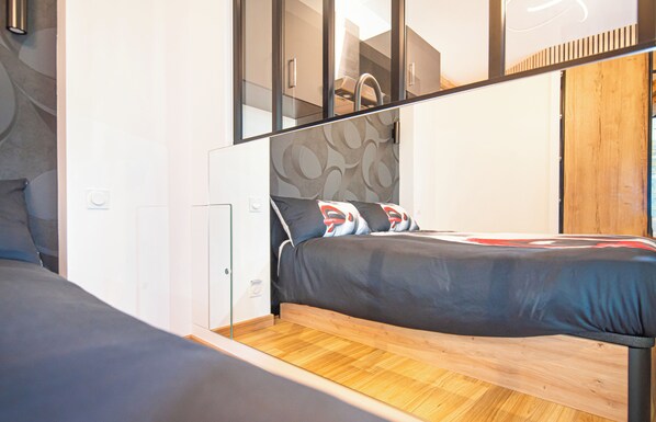 Een moderne slaapkamer met een bed, een kledingkast en een spiegel.