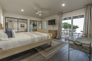 A bedroom with a bed, a ceiling fan, a TV, a window with curtains, and a balcony with outdoor furniture. - Tranquil Green Valley Getaway, Hike, Relax & Spot Rare Birds! (Green Valley)