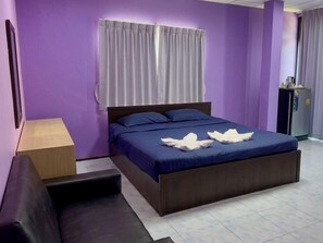 A bedroom with a bed, a nightstand, a sofa, and a refrigerator. - Apartment X5 (Pattaya)