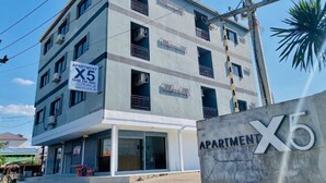 A multi-story apartment building with a sign indicating it is available for rent. - Apartment X5 (Pattaya)