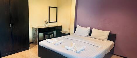 A hotel room with a bed, a desk, and a wardrobe.