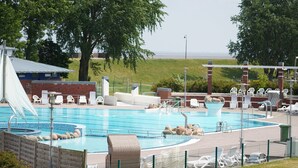 Una piscina con sillas de descanso y vistas al paisaje.