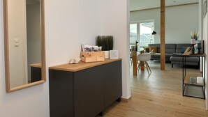 Una sala de estar moderna con piso de madera, un sofá gris y una mesa de centro de madera.