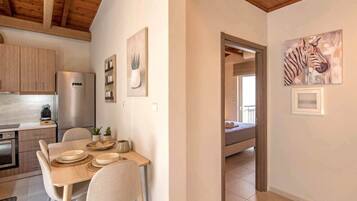 Une cuisine moderne avec des meubles en bois, un réfrigérateur et un coin repas comprenant une table et des chaises.