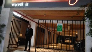A hotel entrance with a neon sign reading "Komfort stay" and a sign indicating a 20% discount. - Komfort Stay (Guwahati)