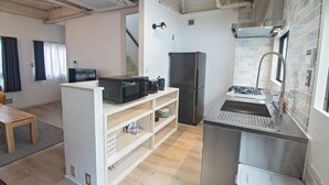 A compact kitchen with a microwave, refrigerator, and sink. - Tabi Time Nishinagahori  (Osaka)