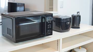 A microwave, toaster, and coffee maker on a white countertop in a kitchen.