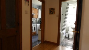 Un couloir menant à la cuisine et à la salle de bain.