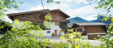 A traditional chalet-style building with a wooden facade, large windows, and a balcony.