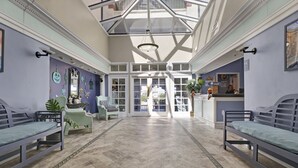 A spacious lobby with a high ceiling, a central open area, and seating arrangements. - Direct ocean view Villa Capriani - just renovated! (North Topsail Beach)