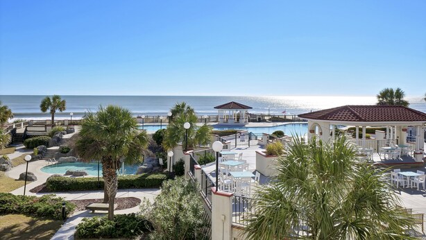 A resort with a pool, outdoor seating, and a view of the ocean. - Direct ocean view Villa Capriani - just renovated! (North Topsail Beach)