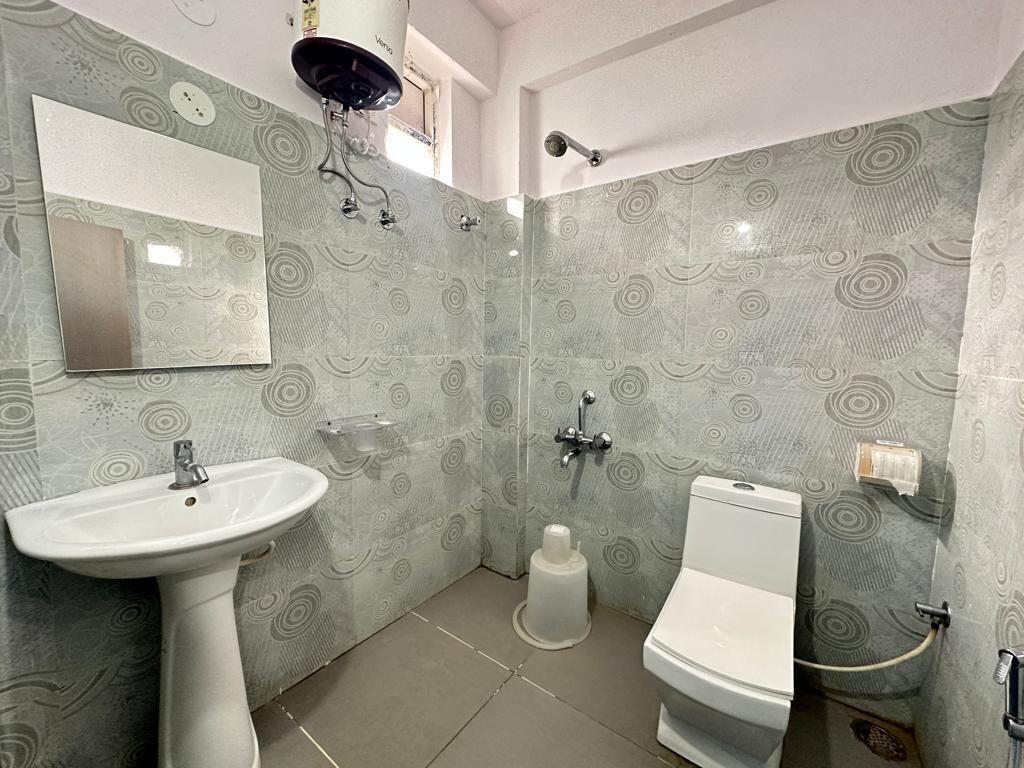 Un bagno con lavabo a piedistallo, water e doccia.