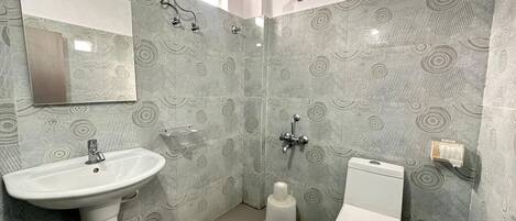 A bathroom with a pedestal sink, toilet, and shower.