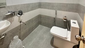 A bathroom with a shower, toilet, and sink.