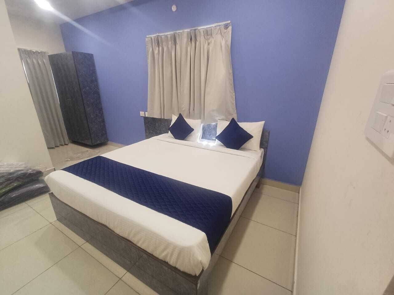 A neatly arranged bedroom with a bed, curtains, and a door.