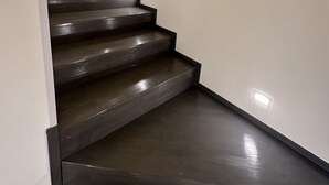 A staircase with dark steps and white walls, leading to a higher floor.