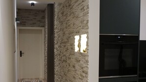 Eine moderne Küche mit eingebautem Kühlschrank und einer Wand mit Steinverkleidung.