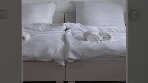Ein Schlafzimmer mit einem Bett, Kissen und einer Wanduhr.
