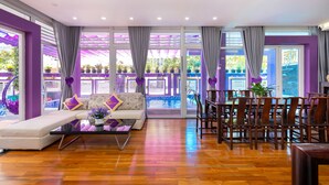 A spacious living area with a sofa, coffee table, and dining area.